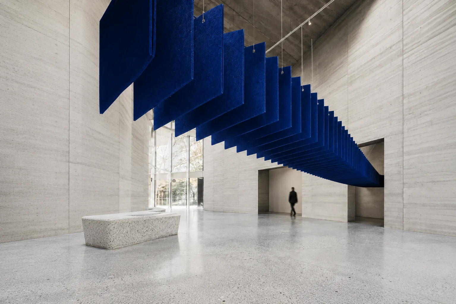 Blue acoustic baffles suspended in a concrete atrium