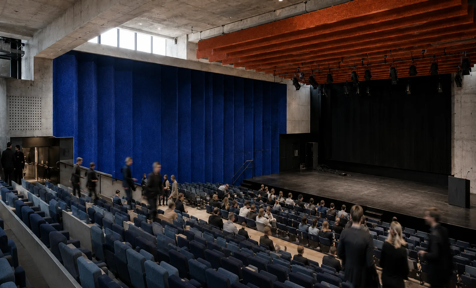 Auditorium with blue acoustic wall and orange ceiling baffles
